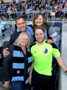 A family of four standing near the sideline at Allianz field. 